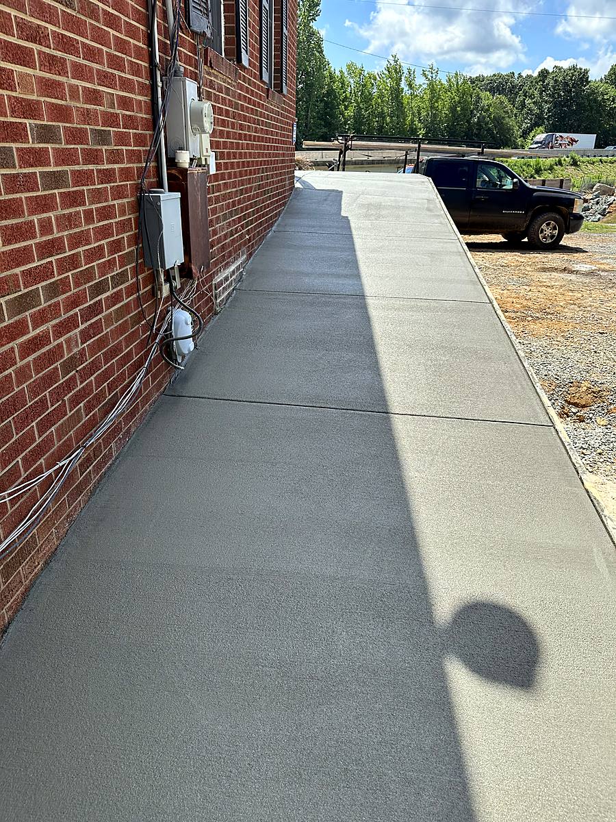Concrete sidewalk along a brick home